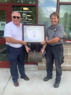 Paul Hanson, left, P.E., regional engineer for the Ductile Iron Pipe Research Association, presents Eric Carty, water and sewer superintendent for the Hopkinton, MA, Department of Public Works, with a plaque welcoming Hopkinton into the association’s Century Club due to a cast-iron pipe in its water system laid in 1877 that remains in use today.