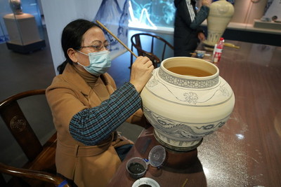 Un artista muestra la pintura, una de las habilidades empleadas en la fabricación de porcelana, en el Museo de porcelana azul y blanca de la dinastía Gao'an Yuan, el 20 de noviembre de 2021. (PRNewsfoto/Xinhua Silk Road)